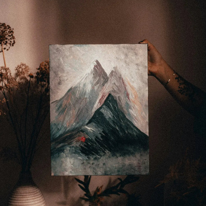 Painting of a snow-capped mountain peak in modern memory design frame against moody sky