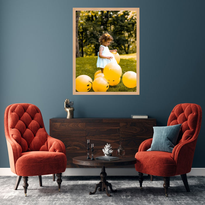 a little girl sitting in a chair with balloons