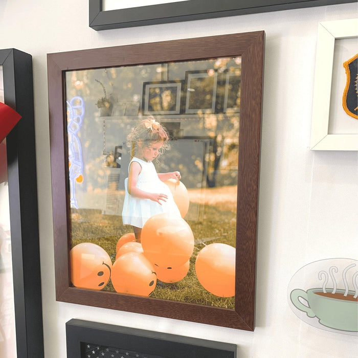 Framed photograph of a child with pumpkins in a 42x46 picture frame on grass