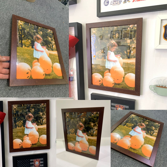 Framed photographs of a person with orange pumpkins in a brown wood picture frame wall hanging