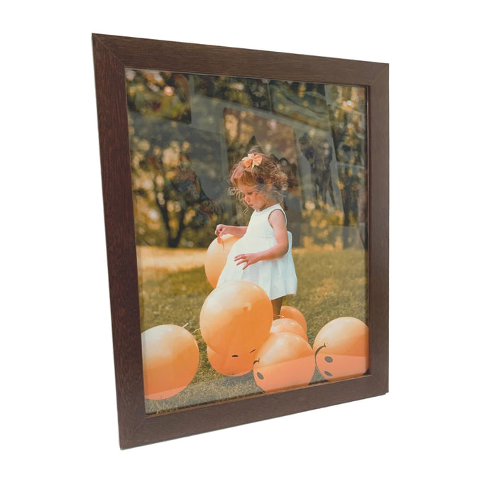 Framed photograph of a child on orange balloons in a stylish wall hanging picture frame