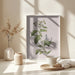 Framed botanical cycling art featuring a flowering plant with green leaves